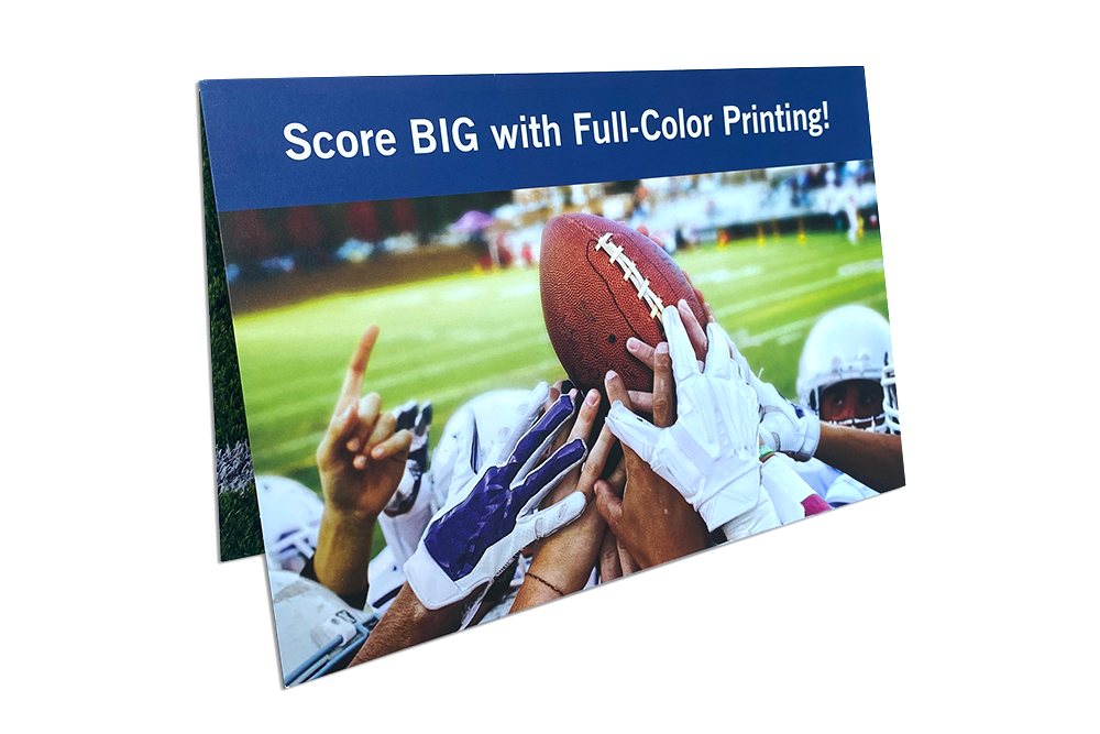 Direct mail print piece with football players holding up a football and the words Score BIG with Full Color Printing
